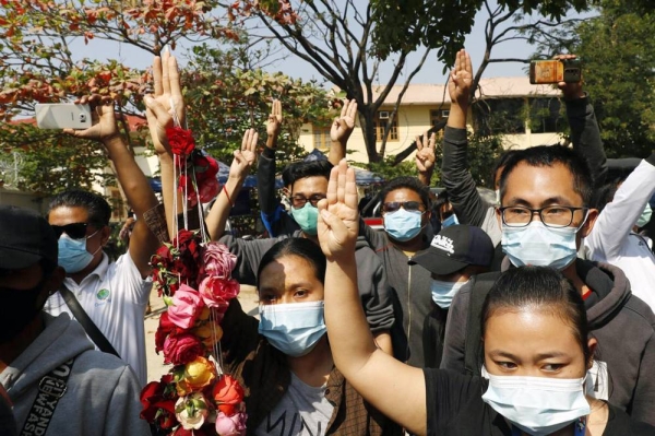 Supporters show the three-finger salute of protest while arrested activist male a court appearance in Mandalay, Myanmar on Friday. Huundred of students and teachers have taken to the streets to demand the military hand power back to the elected politicians.