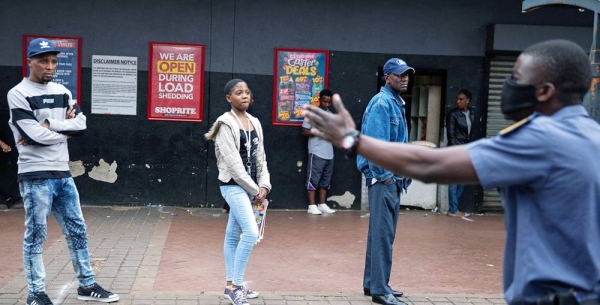 Police order shoppers queuing up outside a shop to maintain a safe distance from each other in Hillbrow, Johannesburg, South Africa, March 30, 2020. — courtesy IMF Photo/James Oatway