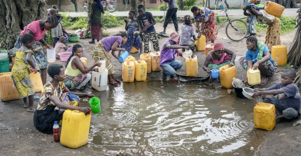 Internally displaced persons, including children, collect water from a broken water main in Uvira, South Kivu, DRC. Waterborne diseases such as cholera are a major threat to displaced populations. — courtesy UNICEF/Patrick Brown