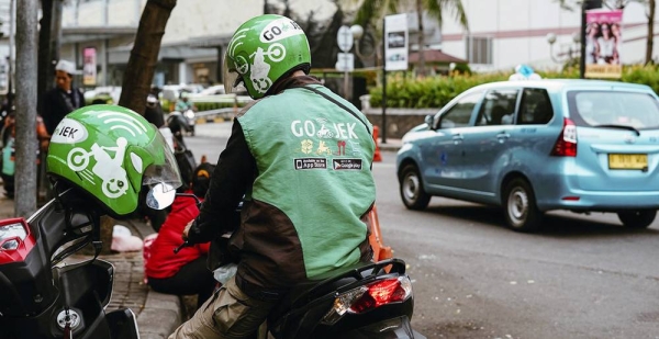 A motorcycle rider from an Indonesian transportation startup waits for a passenger. — courtesy Unsplash/Afif Kusuma