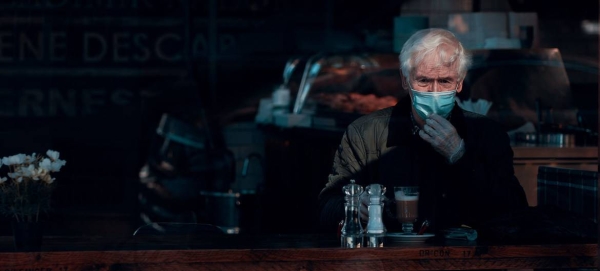 A man wears a face mask and gloves while sitting in a cafe in Glasgow, Scotland. — Courtesy photo
