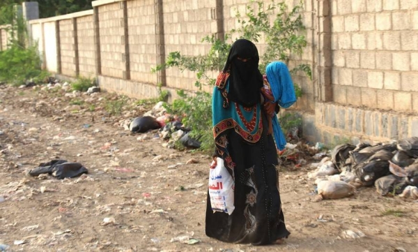 A woman, carrying her child who suffers from severe malnutrition and health complications, walks to a health centre in Hodeidah governorate, Yemen. – courtesy UNICEF/Taha Almahbashi