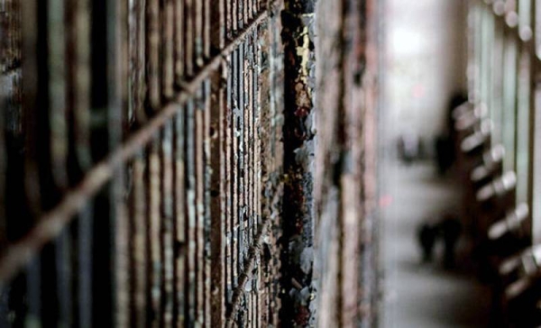 Barbed wire fencing surrounds a detention center. — courtesy Unsplash/Hédi Benyounes