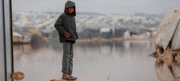 A child is surrounded by floodwater in Kafr Losin Camp in northwestern Syrian. — Courtesy file photo