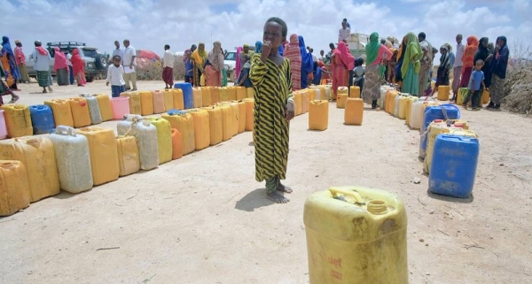 A child stands next to empty containers lined up by people to collect water from a tanker at an IDP camp in Sool region, Somalia.  — courtesy UNICEF/Joe English