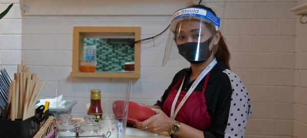 A woman follows health protocols by wearing a face mask at work in a restaurant in Indonesia in this courtesy file photo.