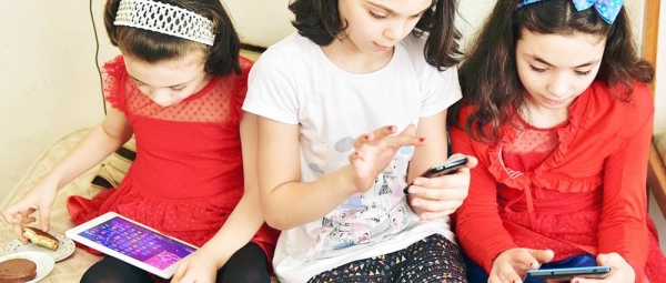 Young girls in Turkey use their digital devices. — courtesy UNICEF/Olcer