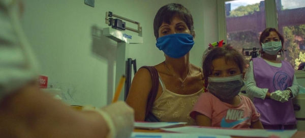 A mother brings her young girl to a medical appointment at a health centre in Caracas, Venezuela, in this courtesy file photo.
