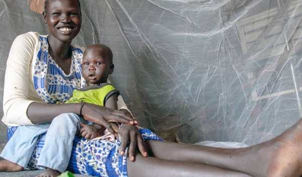 A mother and her nine-month-old baby sit under a UNICEF-supplied bed net in Upper Nile state, South Sudan. — courtesy UNICEF/Mark Naftalin