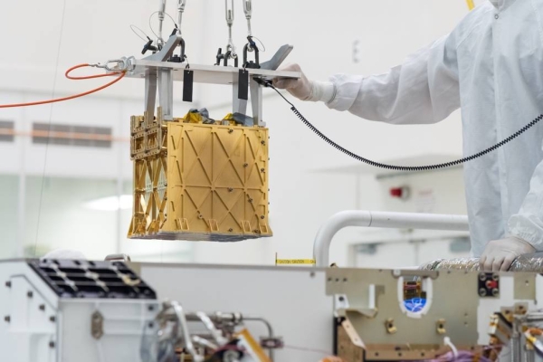 Technicians at NASA's Jet Propulsion Laboratory lower the Mars Oxygen In-Situ Resource Utilization Experiment (MOXIE) instrument into the belly of the Perseverance rover. — Courtesy NASA
