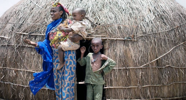 A woman and her young sons stand in front of their shelter in a camp for displaced people in Baboua, Central African Republic. — courtesy UNICEF/Florent Vergnes