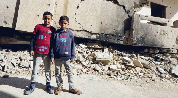 File photo shows young boys standing in front of a destroyed building in Benghazi Old Town in Libya. — courtesy UNOCHA/Giles Clarke