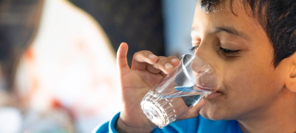 A young boy drinks a glass of water from a new water network connected to the Za'atari Refugee Camp in Jordan. — Courtesy file photo
