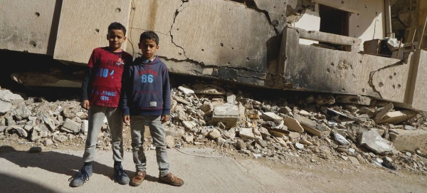 Young boys stand in front of a destroyed building in Benghazi Old Town in Libya. — Courtesy file photos
