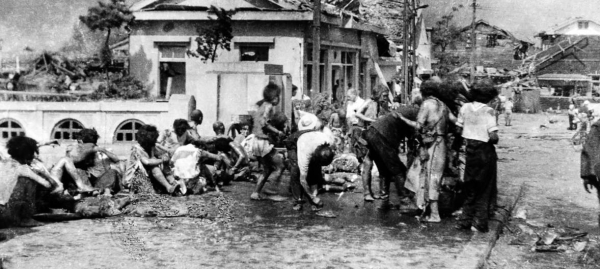 Injured civilians, having escaped the raging inferno, gathered on a pavement west of Miyuki-bashi in Hiroshima, Japan, about 11 a.m. on  Aug. 6, 1945. — Courtesy file photo
