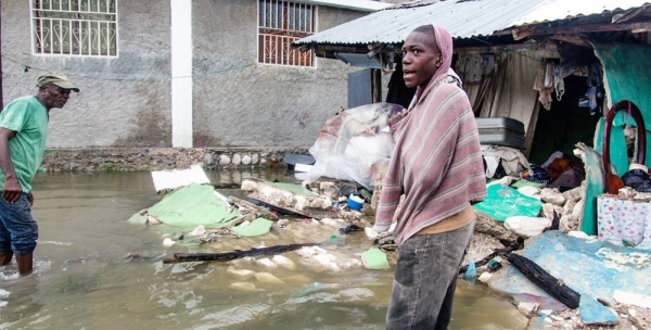 A young man stands outside a row of buildings destroyed by a 7.2 magnitude earthquake in Haiti followed by a storm surge from Tropical Depression Grace. — courtesy UNICEF/Georges Harry Rouzier
