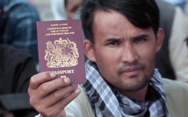 A desperate Afghan would-be migrant flashes his passport in an effort to get the nod during the evacuation process in Kabul airport.