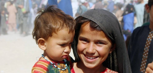 A seven-year-old girl holds her younger sister in an IDP camp in Kandahar, southwestern Afghanistan. — courtesy UNICEF Afghanistan