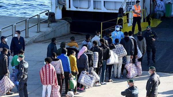 In this file photo from May 2021, migrants are seen before boarding a ship on being transferred from the migrant center on Lampedusa island.