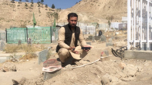 Emal Ahmadi, who lost 10 family members in a drone strike, mourns them at a Kabul graveyard.