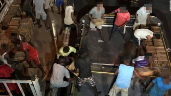 People are seen loading crates of weapons onto an Ethiopian Airlines plane at an airport in Massawa, Eritrea. Some faces have been blurred to preserve anonymity.