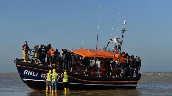 Migrants stand aboard a lifeboat after being rescued crossing the English channel at Dungeness, England.