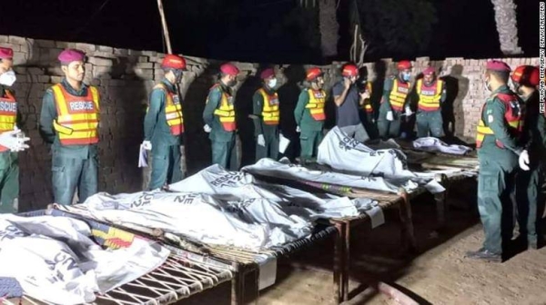 Rescue workers gather near the bodies of the victims in Muzaffargarh, Pakistan, on October 17.