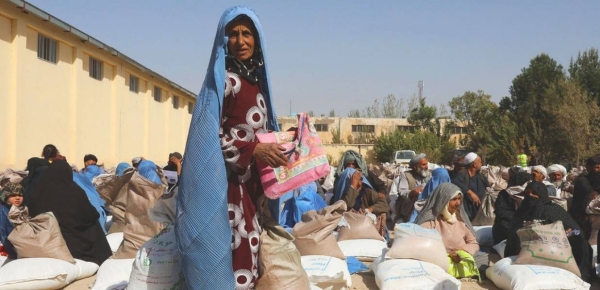 People receive food rations at a WFP distribution site on the outskirts of Herat in Afghanistan.