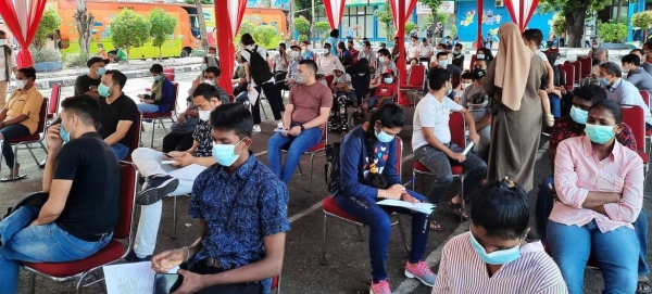 The Governor of DKI Jakarta together with UNHCR Indonesia Representative and members of KADIN (Indonesia Chambers of Commerce and Industry) observe a young refugee being vaccinated. — courtesy UNHCR Indonesia