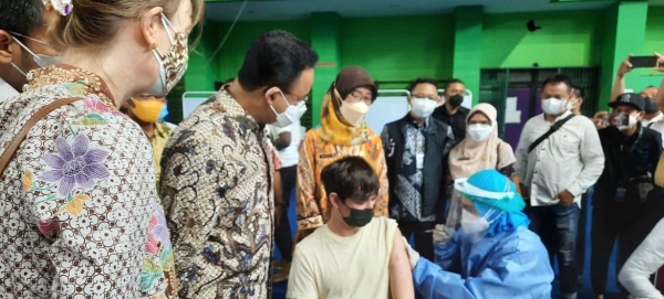 The Governor of DKI Jakarta together with UNHCR Indonesia Representative and members of KADIN (Indonesia Chambers of Commerce and Industry) observe a young refugee being vaccinated. — courtesy UNHCR Indonesia