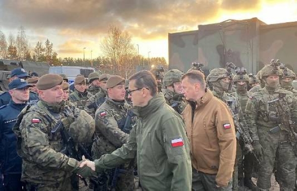 Poland's Prime Minister Mateusz Morawiecki (C) and Defence Minister Mariusz Blaszczak (R) meet border guards and troops at Kuznica, Poland-Belarus border, Nov. 9, 2021.