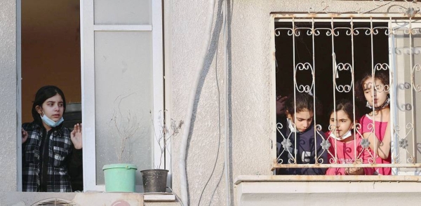 Palestinian children look out from their house window at destroyed buildings in their neighborhood in the Gaza City. — courtesy UNICEF/Eyad El Baba