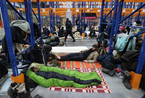 Migrants settle for the night in the logistics center in the checkpoint 