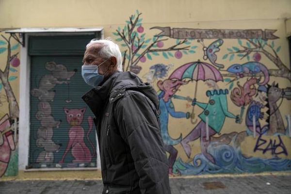 A man wearing a face mask to protect against coronavirus walks in Athens.