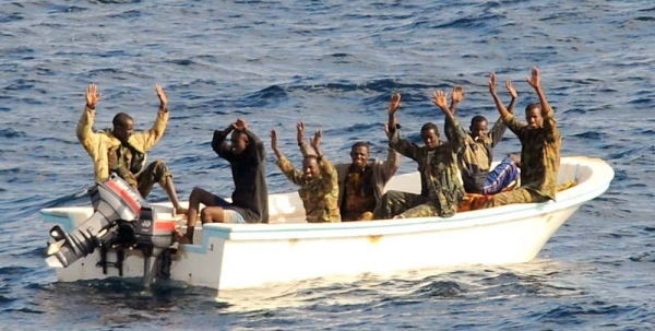 Suspected pirates wait for members of the counter-piracy operation to board their boat. — courtesy US Navy/Jason R Zalasky