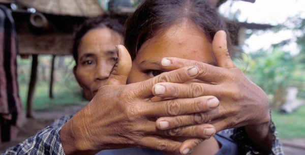 A mother whose daughter was trafficked at the age of sixteen covers her face to protect her identity. — courtesy UNICEF/Jim Holmes