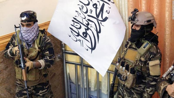 Taliban fighters stand guard next to a Taliban flag during a gathering where Afghan Hazara elders pledged their support to the country's new Taliban rulers, in Kabul on Nov. 25, 2021. — courtesy photo