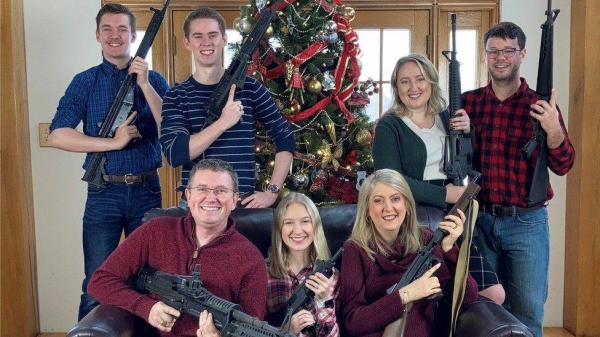 Congressman Thomas Massie and his family bearing a collection of military-style assault rifles.
