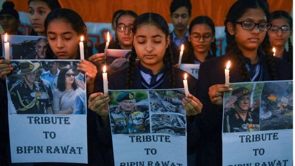 Students hold candles and posters to pay tribute to India's defense chief General Bipin Rawat, at their school in Amritsar on December 9, 2021.
