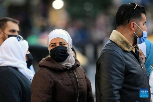 امرأة ترتدي قناعا في عمان.  (شينخوا)