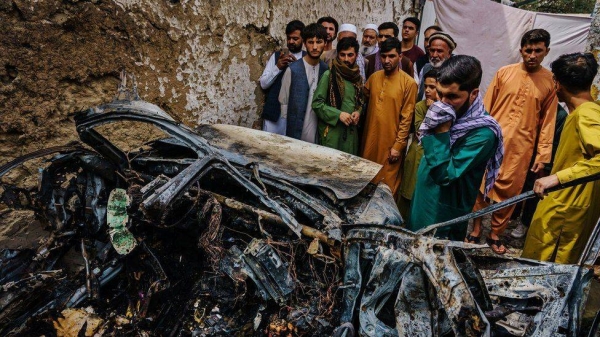 
Relatives and neighbors of the Ahmadi family gathered around the incinerated husk of a vehicle targeted and hit by an US drone strike that killed 10 civilians including 7 children, in Kabul, Afghanistan on Aug. 30, 2021.
