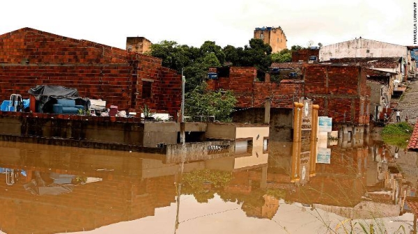 Families in flood-hit Itapetinga move furniture to their rooftops on December 26.