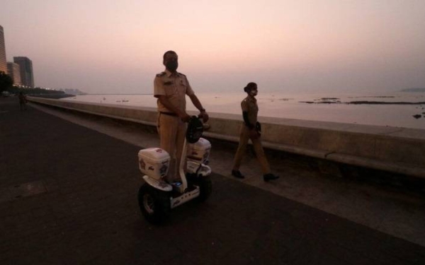 A policeman patrols the promenade at Mumbai's Marine Drive to limit public gatherings