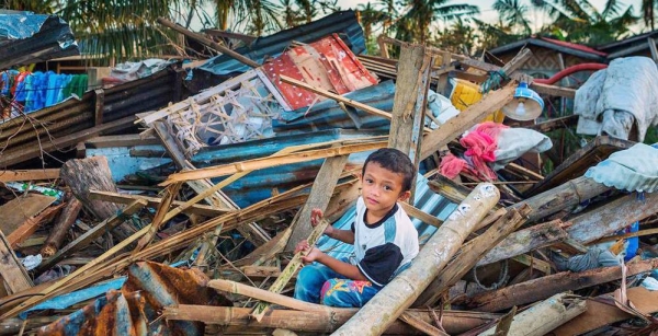 A boy sits in the debris of homes destroyed by Typhoon Rai in the Purok district of the Philippines. — courtesy UNICEF/David Hogsholt