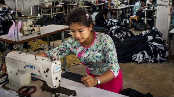 A migrant worker sews clothes in a factory in western Thailand.
