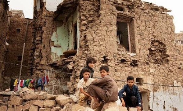 Children sit in front of a house damaged by an air strike, inside the old city of Sana'a, Yemen. 
