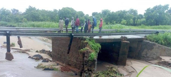 People stand on a damaged bridge in the aftermath of Tropical Storm Ana making landfall in Mozambique.
