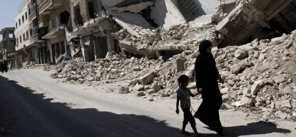 A young girl and a woman walk past destroyed buildings in Idlib governerate in northwest Syria.