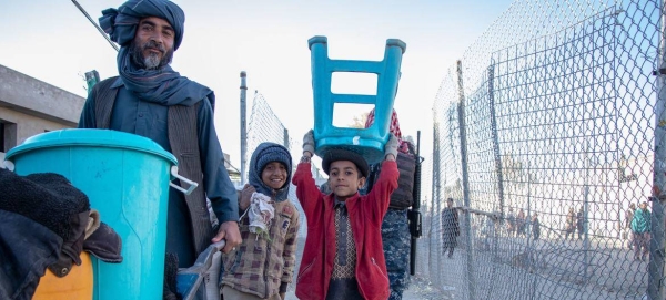 A displaced family carrying their belongings in Kandahar, Afghanistan.