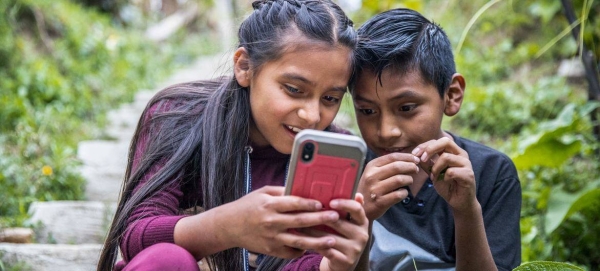 Two children play outside while their parents participate in a workshop about online security and positive parenting practices in Guatemala.